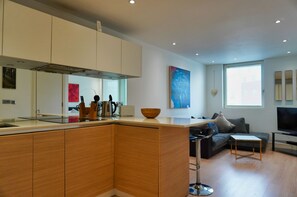 Apartment, 1 King Bed | Living area | Flat-screen TV, heated floors