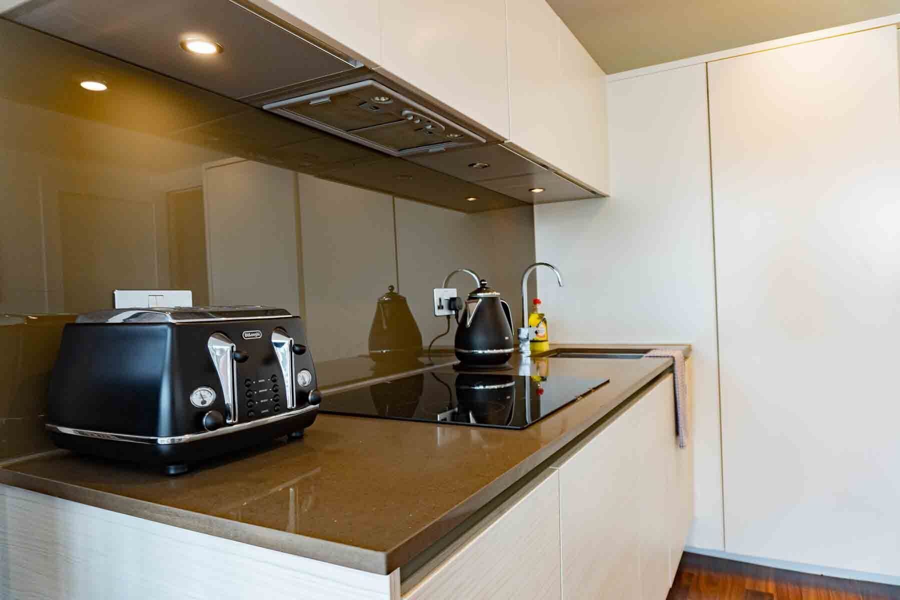 A compact kitchen with a toaster, kettle, and a small countertop.