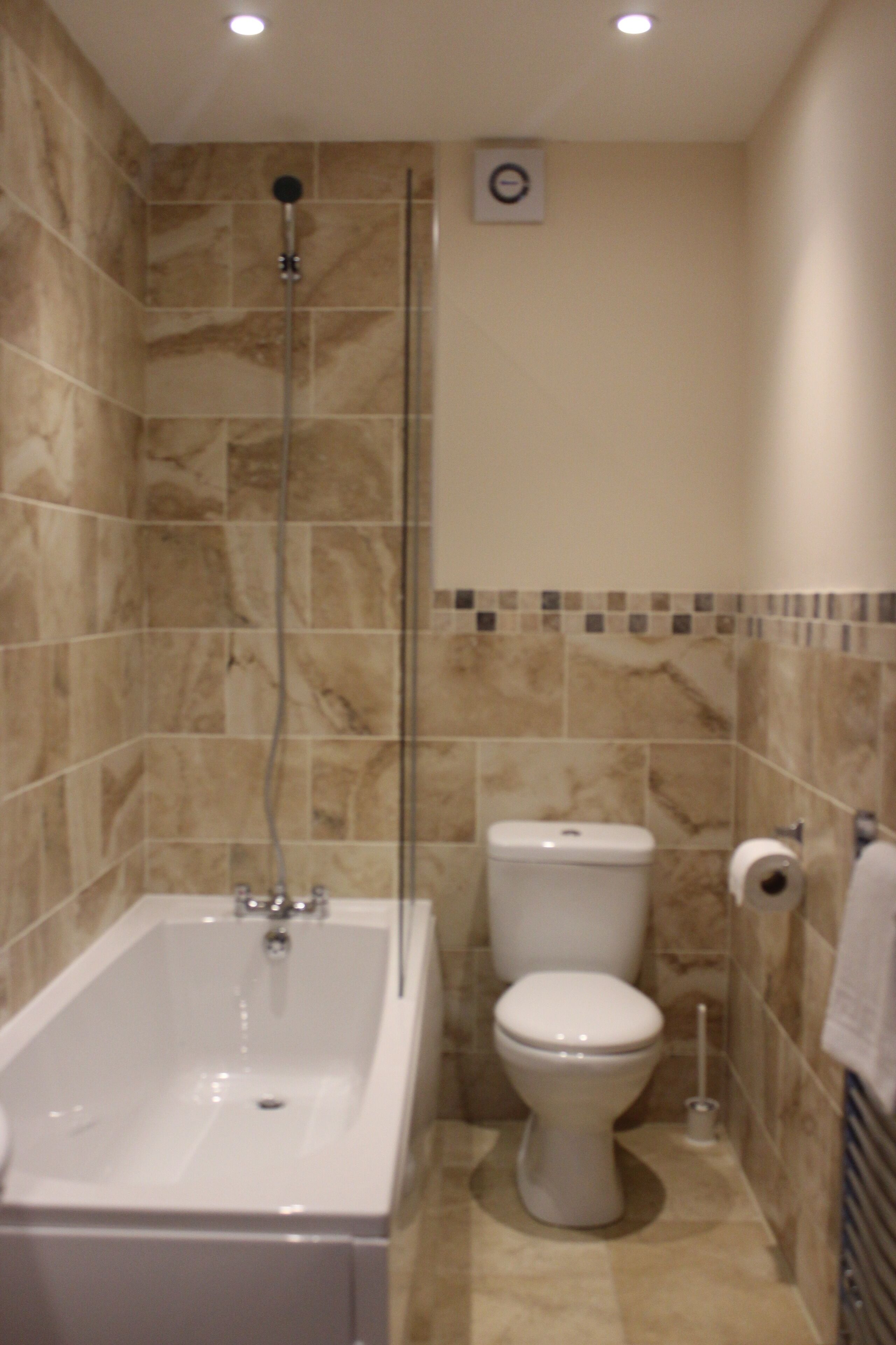 A bathroom with a bathtub, toilet, and shower.