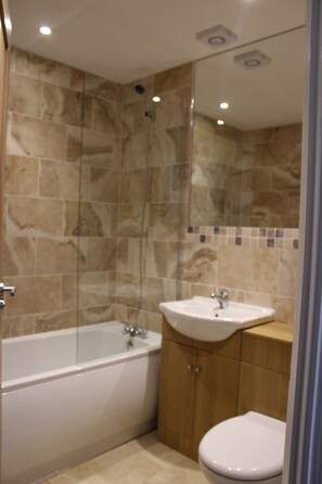 A bathroom with a bathtub, sink, and toilet.
