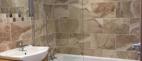 A bathroom with a bathtub, a sink, and a toilet.