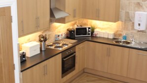 Una cocina moderna con armarios de madera, un microondas, una estufa y un lavaplatos.