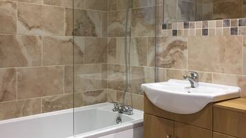 Une salle de bain avec une baignoire, une douche et un lavabo.