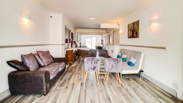 A spacious living area with a sofa, chairs, and a dining table. - The Longlands Hotel (Middlesbrough)
