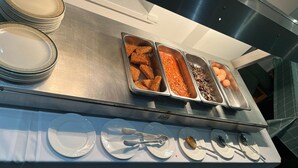 A buffet setup with various food items and utensils. - The Longlands Hotel (Middlesbrough)