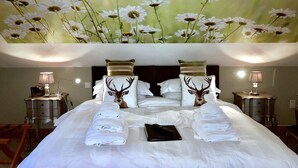 A hotel room with a large bed, two nightstands, a lamp, and a painting of daisies on the ceiling. - Ashbrook House B&B (Dungannon)