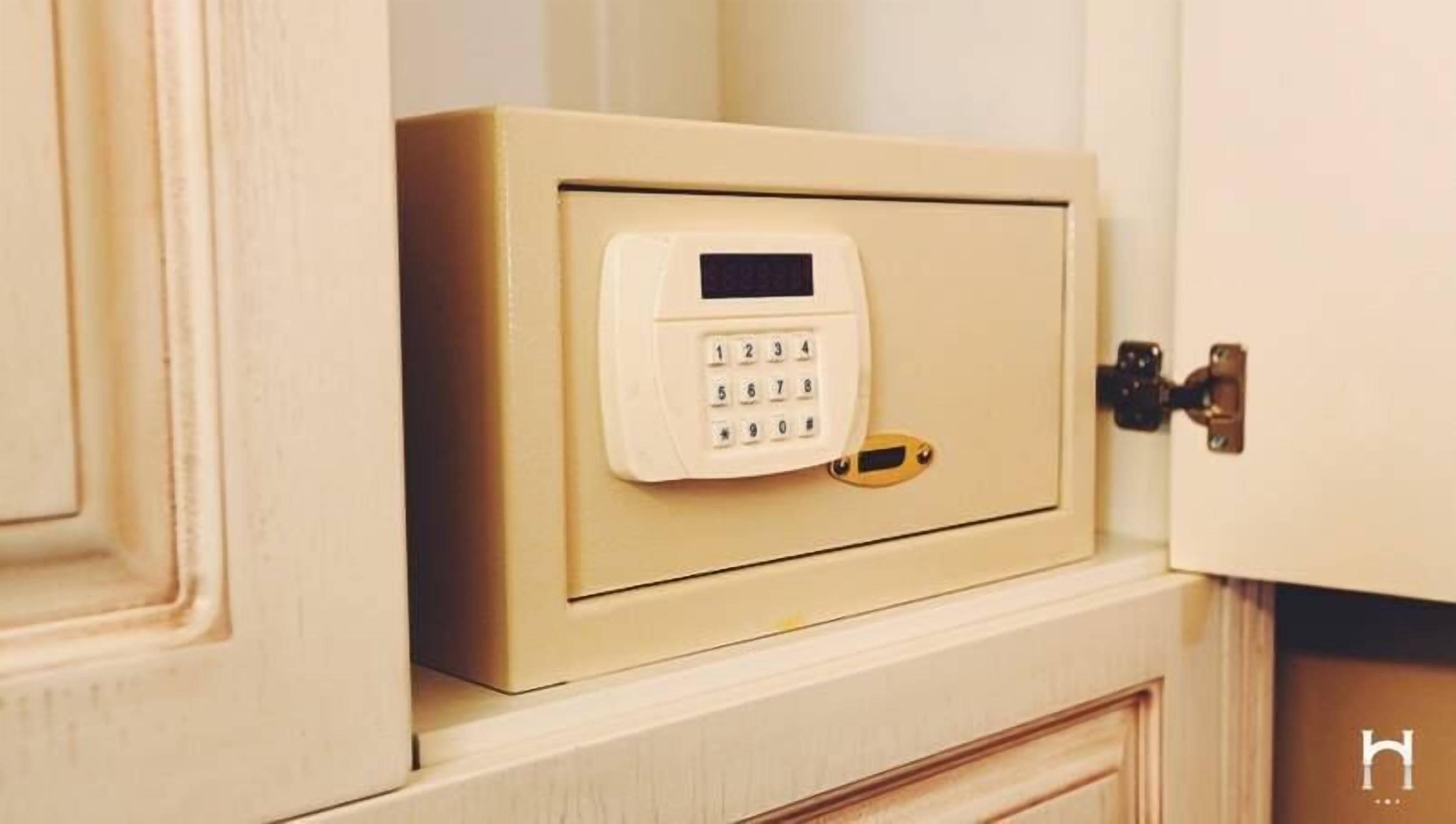 Een beige kluis met een keypad en een gouden slot.