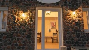 A stone facade with a sign reading "Villa Thiranthemis." - Villa Thiranthemis - Adults Only (Santorini)