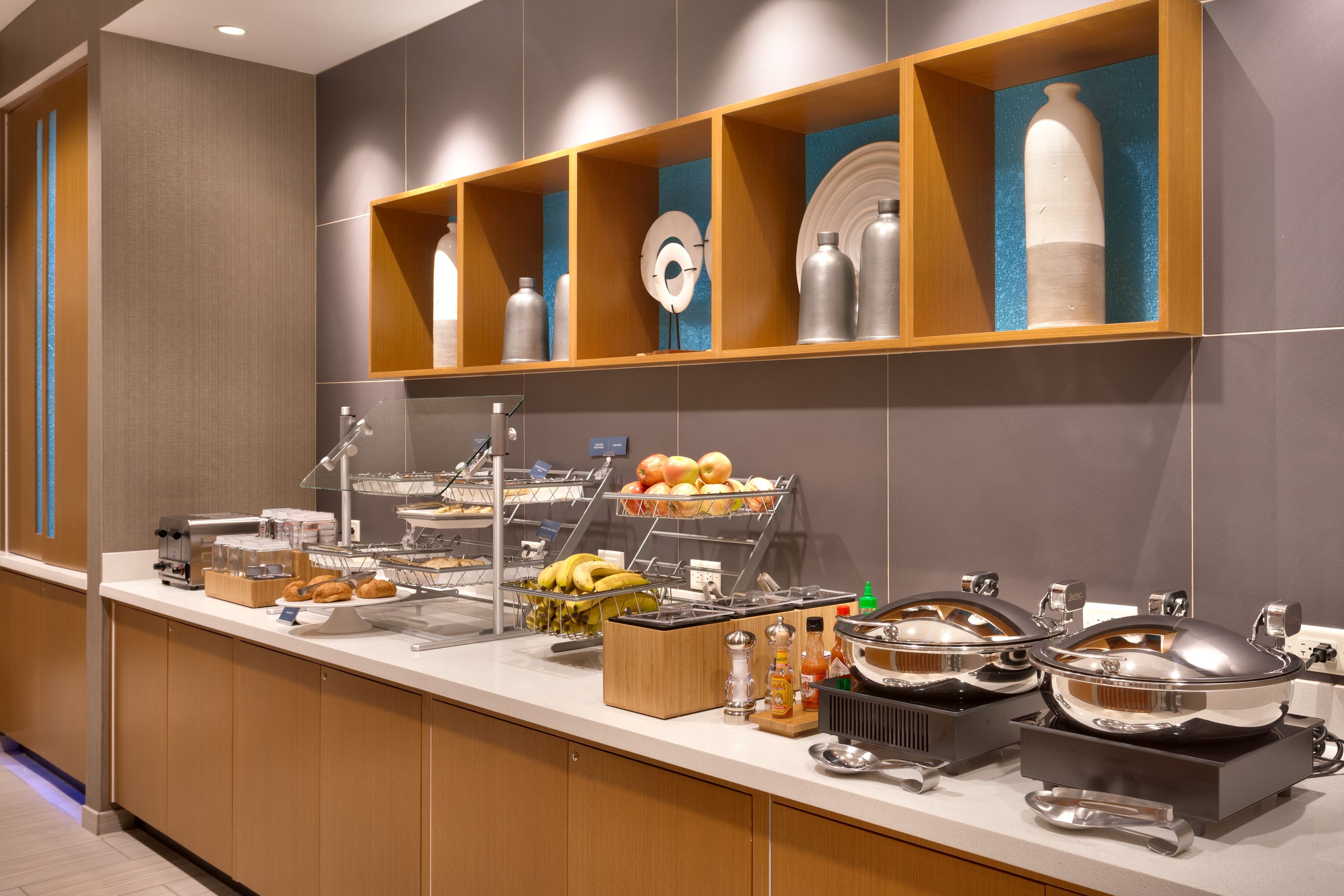 A buffet setup with various food items and condiments.