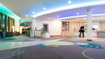 Welcome to our lobby, where a curved ceiling and playful floor pattern create a warm atmosphere.