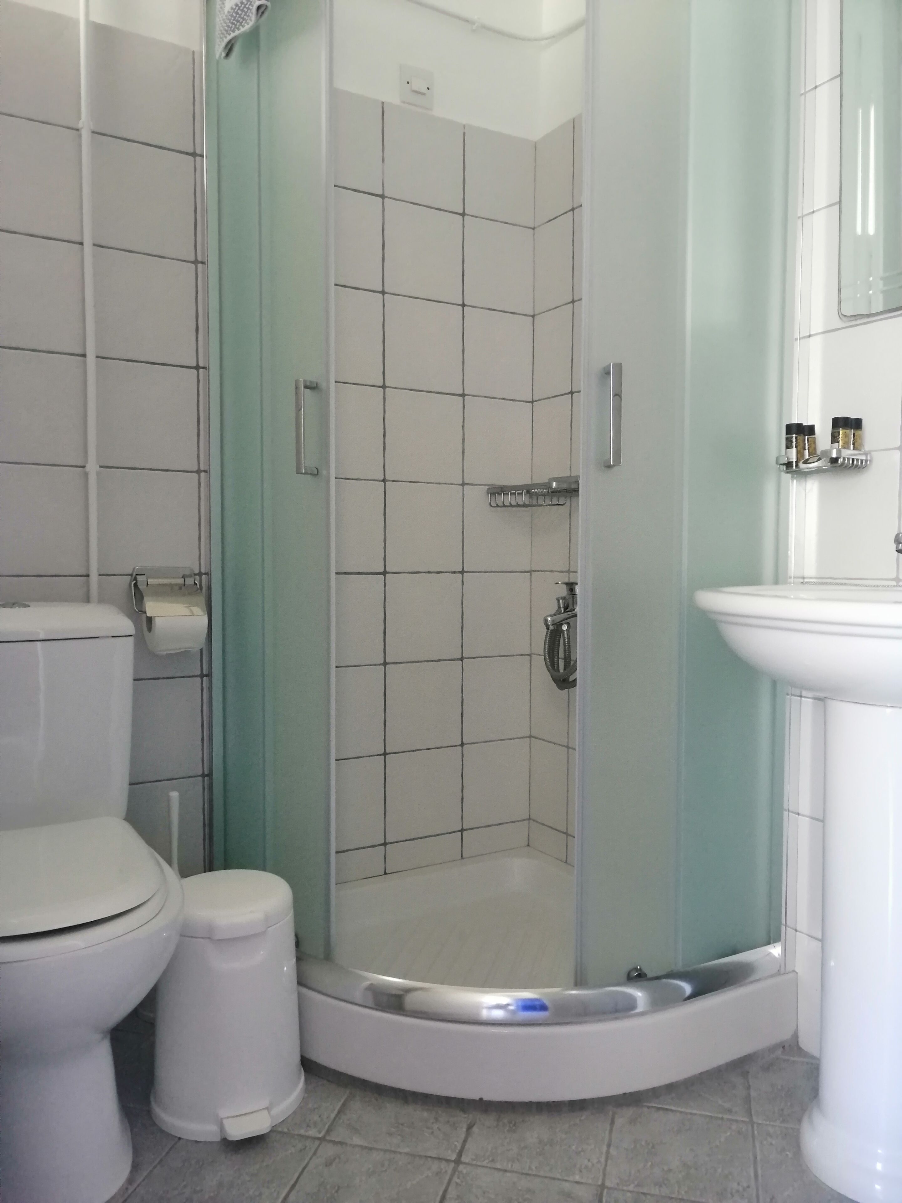 Un baño con ducha, inodoro y lavamanos.