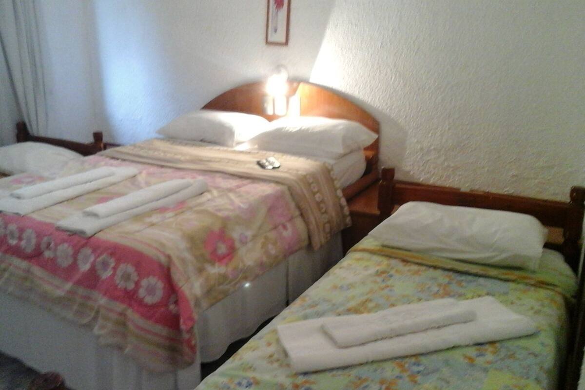 Una habitación de hotel con dos camas individuales, cada una con una colcha estampada y almohadas blancas.