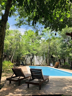 Una piscina al aire libre, tumbonas