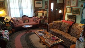 Een gezellige woonkamer met twee banken, een salontafel met boeken en een kamerbreed tapijt.