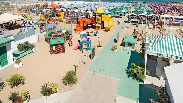 Un complexe hôtelier en bord de mer, doté d’une aire de jeux pour enfants, de parasols de plage et d’une piscine.