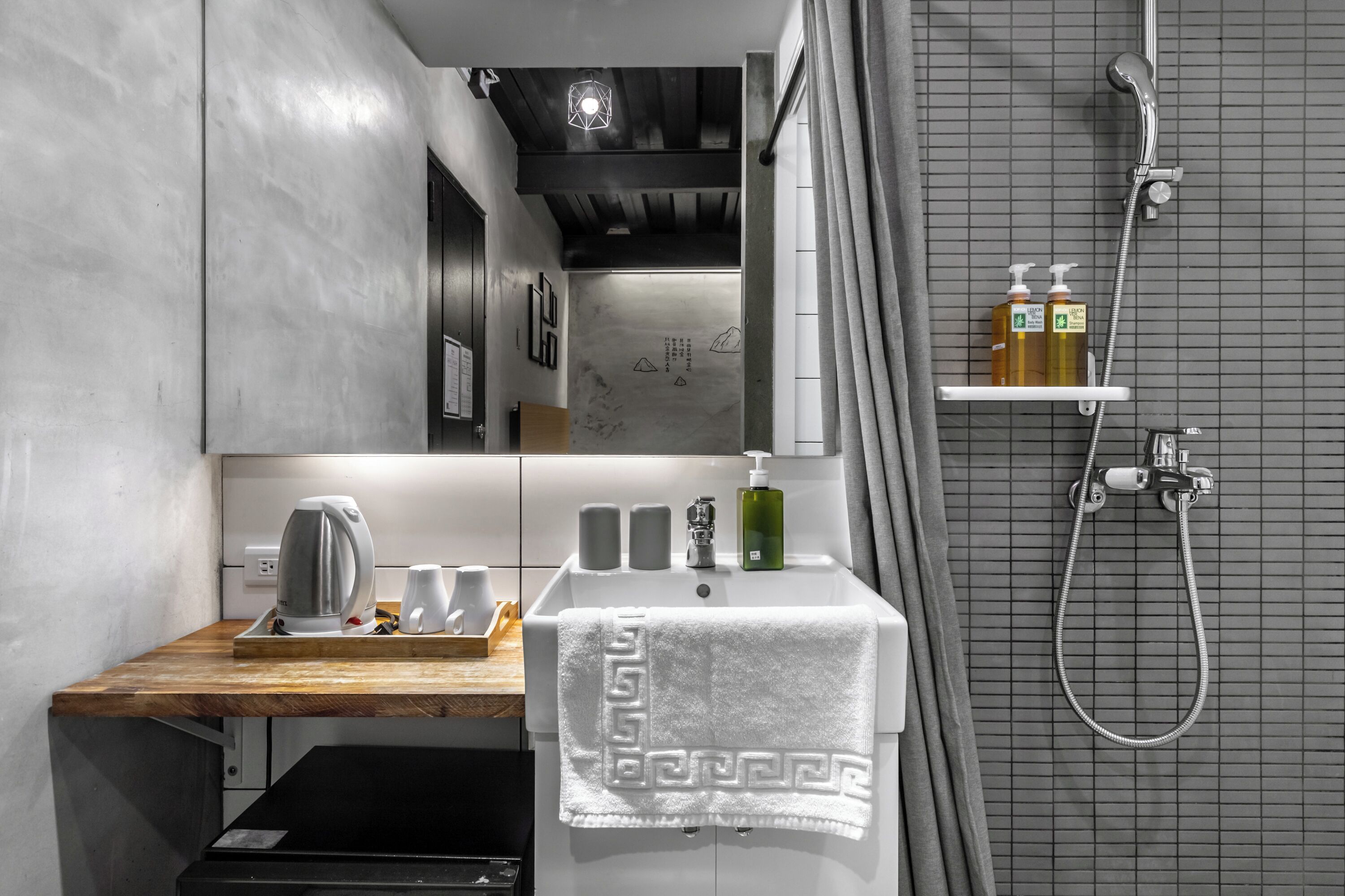 A modern bathroom with a wooden countertop, a sink with a towel, and a shower area.
