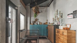 A narrow, industrial-style kitchen with a blue tiled backsplash, wooden cabinets, and hanging plants. - Jiufen The Ore Inn (New Taipei City)