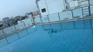 Ein Dachpool mit gefliestem Boden und einem Metallgeländer.