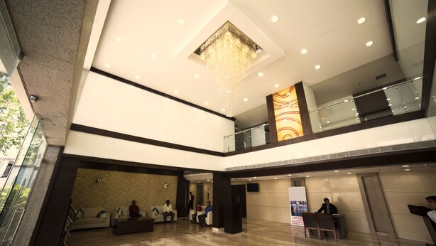 Eine moderne Lobby mit Empfangstresen, Sitzgelegenheiten und einer Wanddekoration.