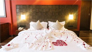 A hotel room with a large bed, two bedside lamps, a wooden headboard, and a nightstand with a phone. - Trance Greenfields Resort and Convention Centre (Hyderabad)