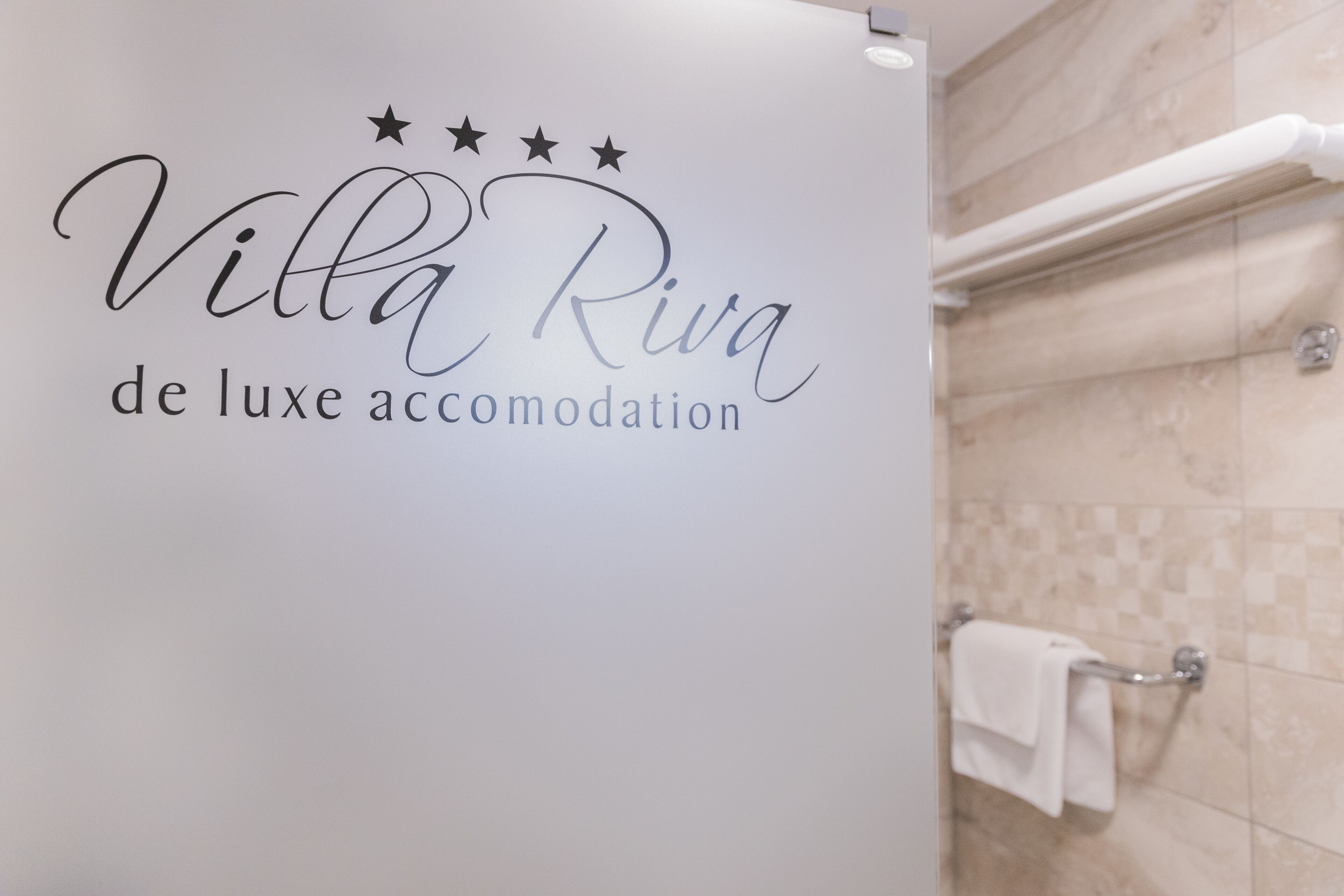 Un baño con un toallero de pared y pared con azulejos.