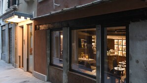 Un restaurante con amplios ventanales y un interior a la vista, con mesas y sillas.