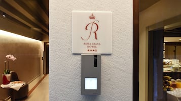 A sign for Rosa Salva Hotel with a crown logo and three stars.