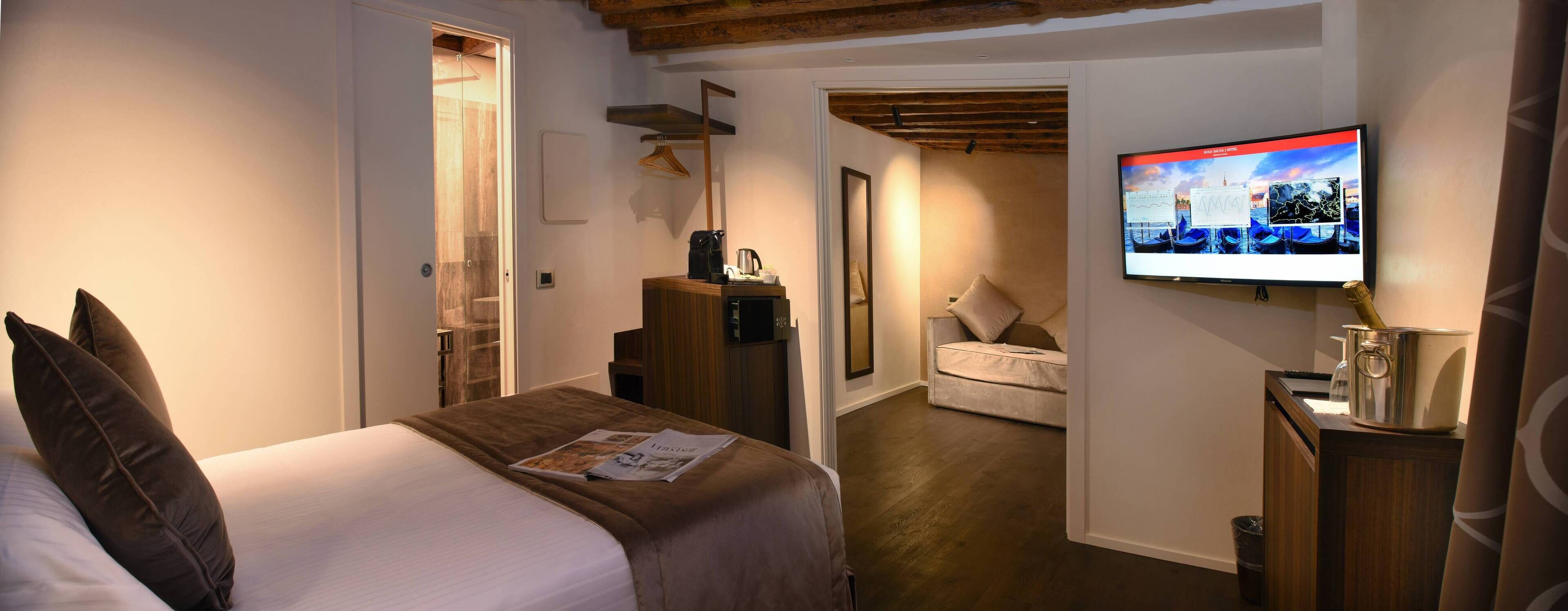 A hotel room with a bed, a TV, a desk, and a chair.