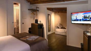 Una habitación de hotel con una cama, televisión, escritorio y una silla.