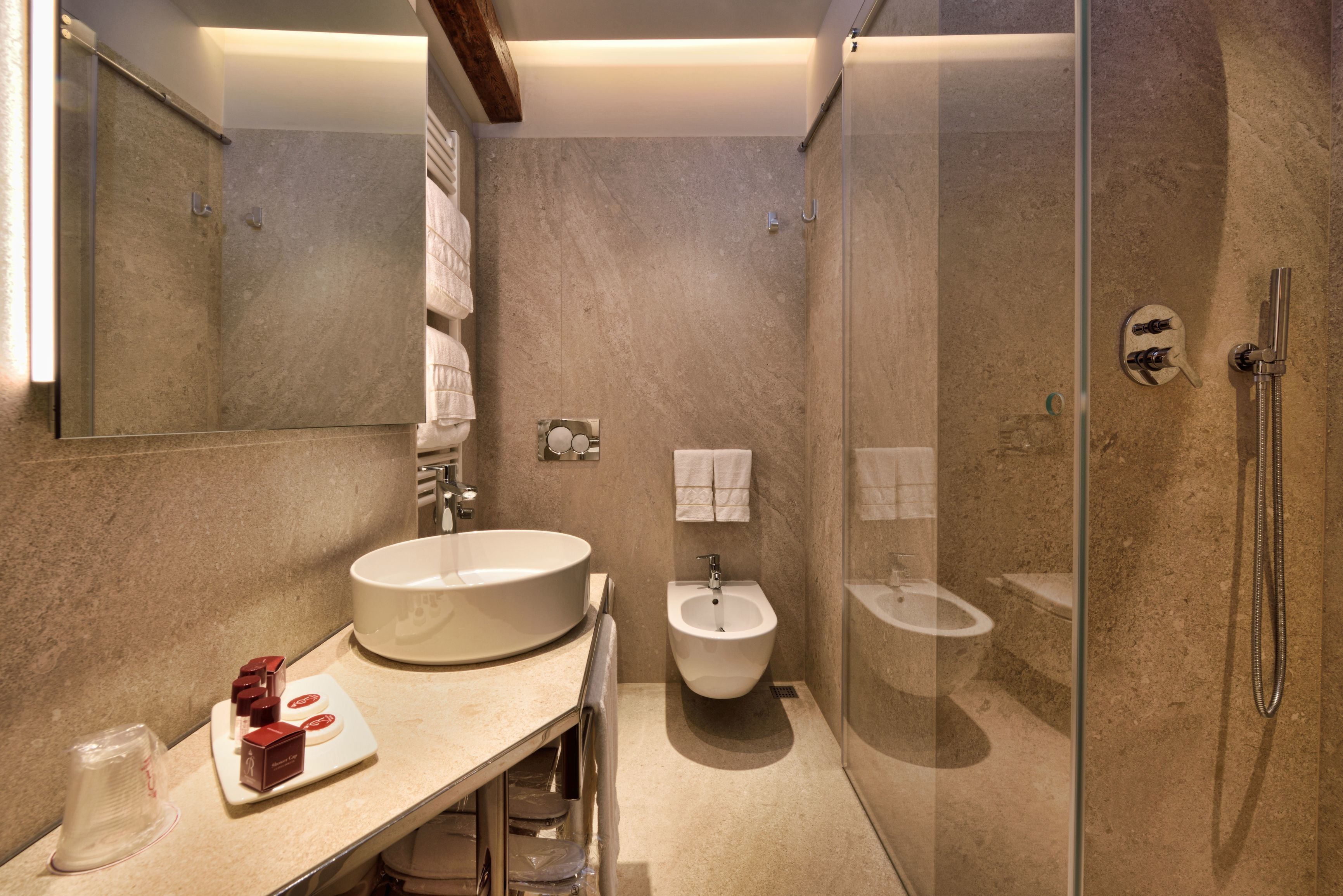 A modern bathroom with a large sink, bidet, and glass-enclosed shower.
