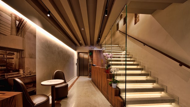 Un vestíbulo moderno con una escalera, zona de estar y una recepción.