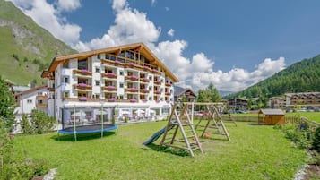 Experience the charm of the Alps in this traditional hotel, surrounded by lush greenery and majestic mountains.