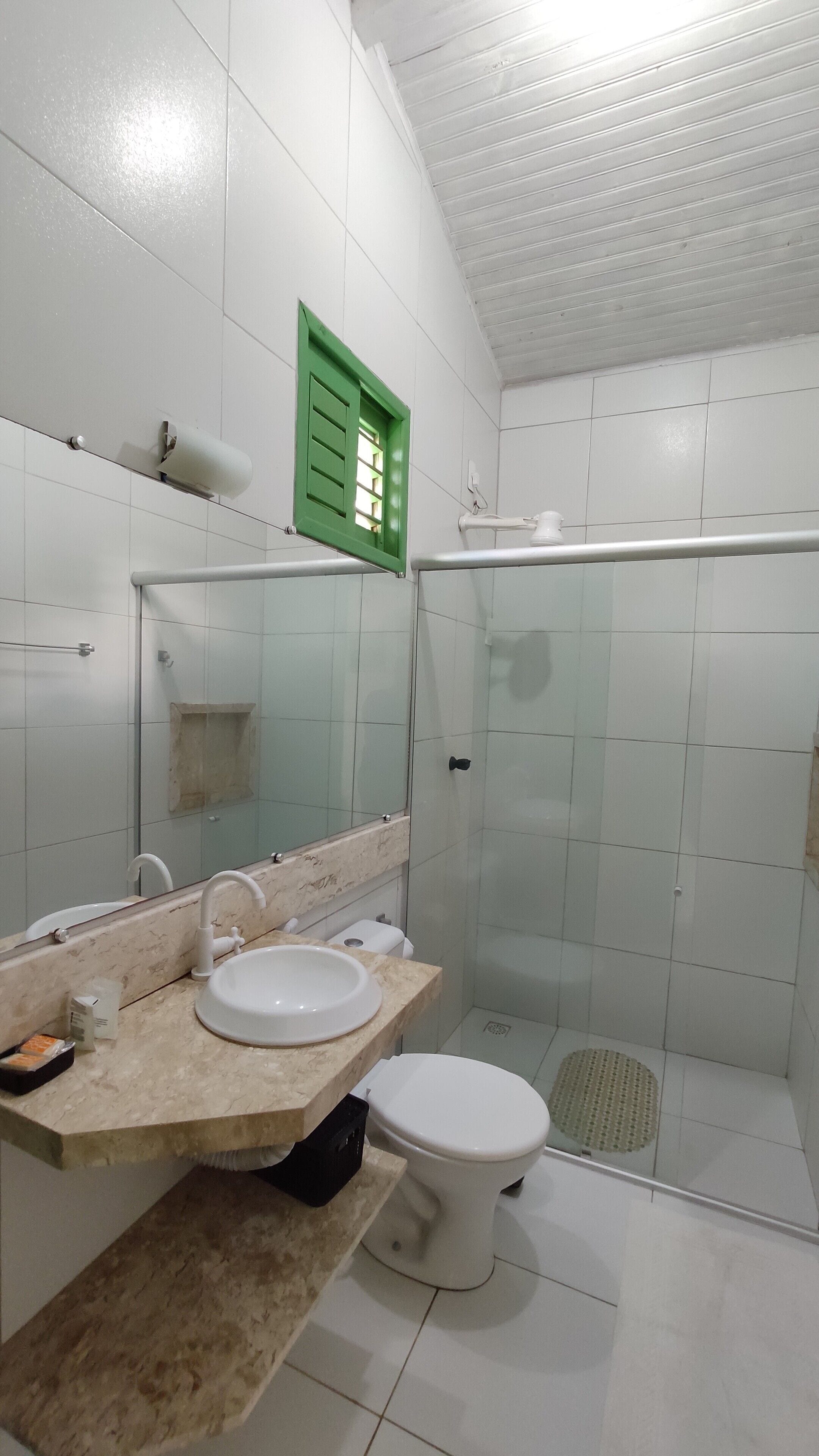 Un baño con inodoro, lavabo y zona de ducha.