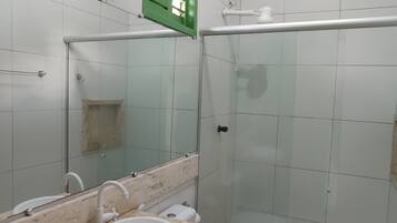 Un baño con inodoro, lavabo y zona de ducha.