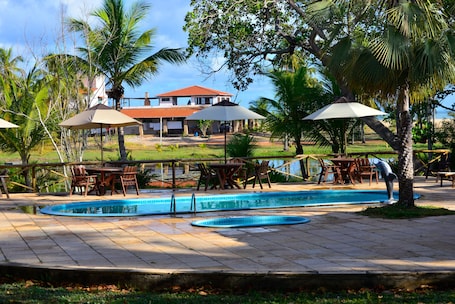 Una piscina al aire libre, sillones reclinables de piscina