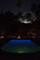 Una piscina al aire libre, sillones reclinables de piscina