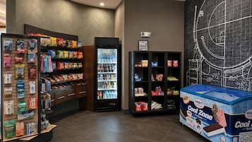 Een hoekje voor snacks en drankjes, met een koelkast, gevulde planken en een ijswinkel.