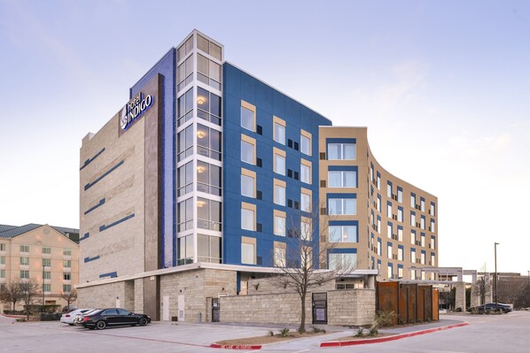 Un hôtel moderne, doté d’une enseigne bien visible, de plusieurs étages et d’un parking.