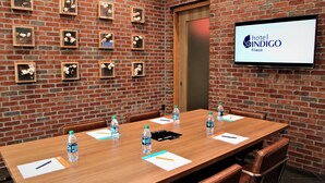 A conference room with a long wooden table, chairs, water bottles, and name cards.