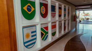 Corredor com bandeiras do Brasil, Portugal, Uruguai, África do Sul e dos Estados Unidos.