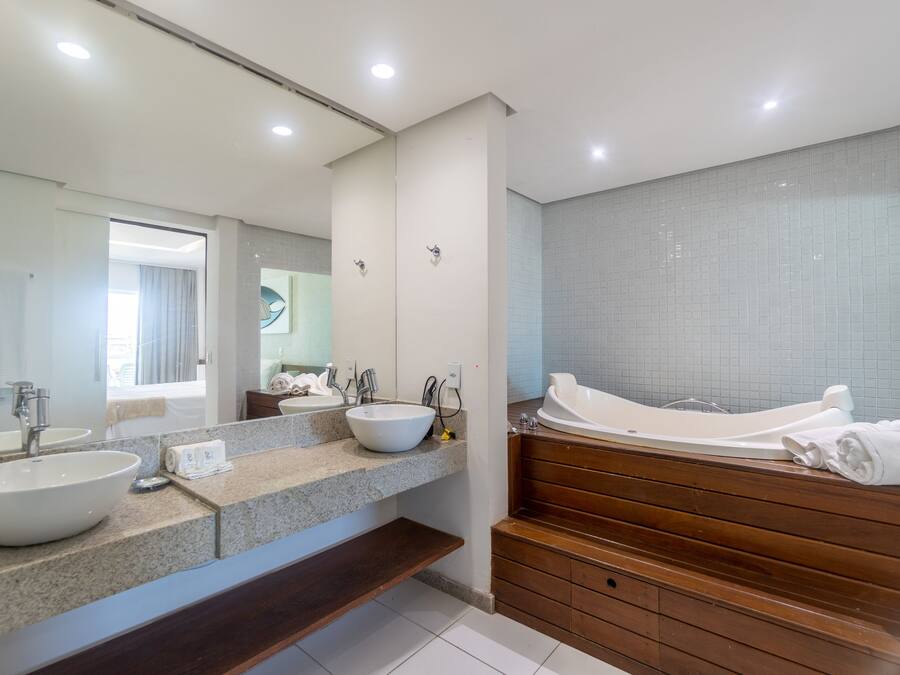 Een moderne badkamer met twee wasbakken, een grote spiegel en een bad.