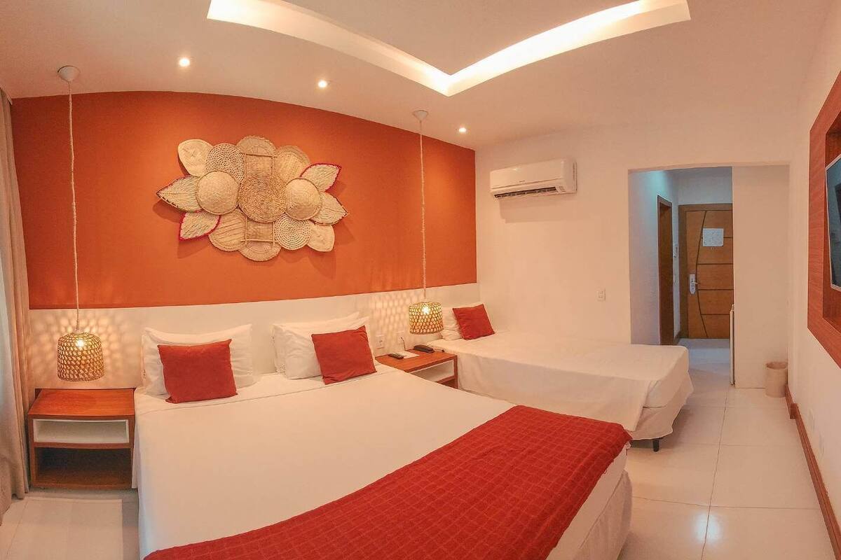 Una habitación de hotel moderna con dos camas, un adorno en la pared y una lámpara en el techo.
