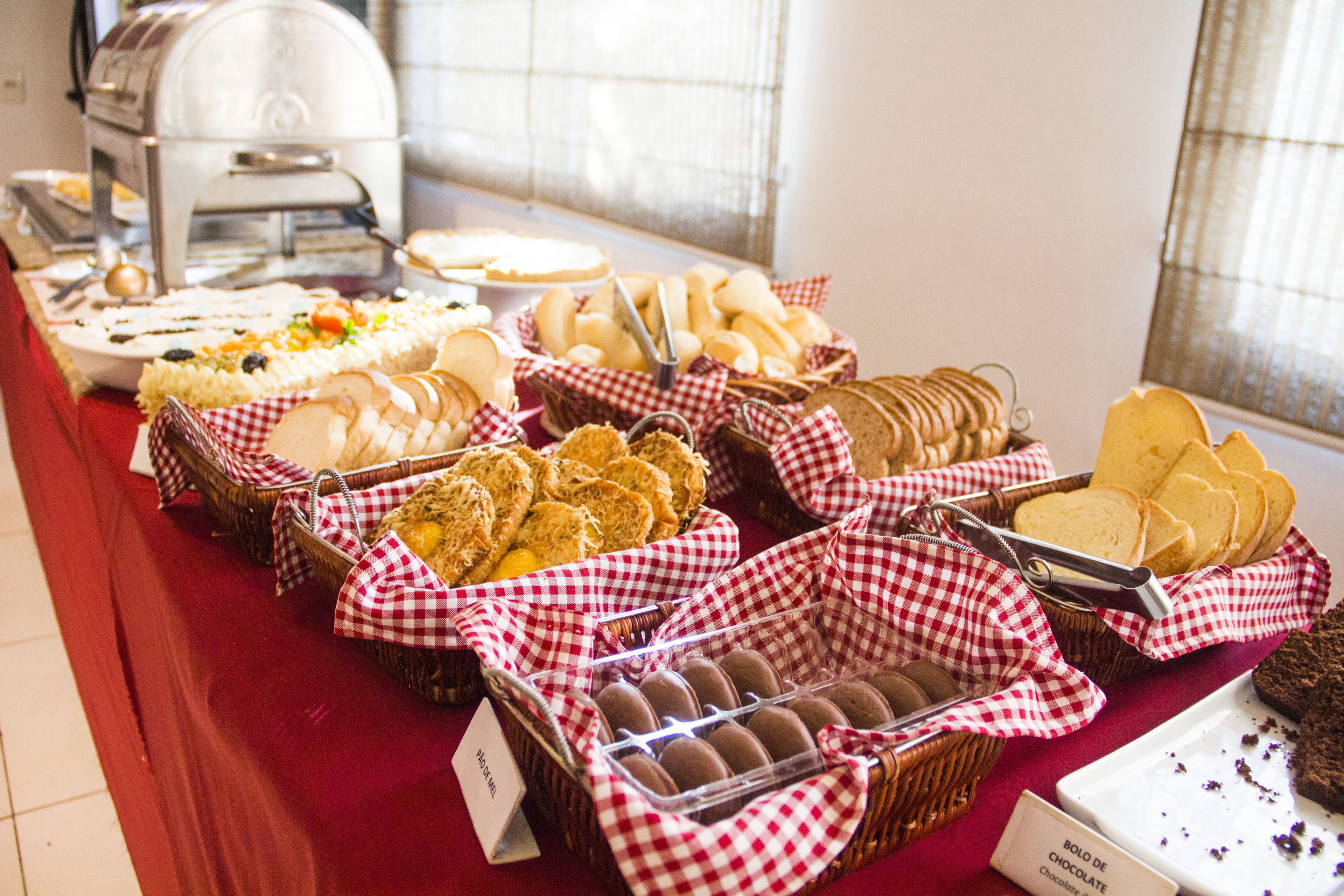 A buffet table with various food items including bread, pastries, and desserts.