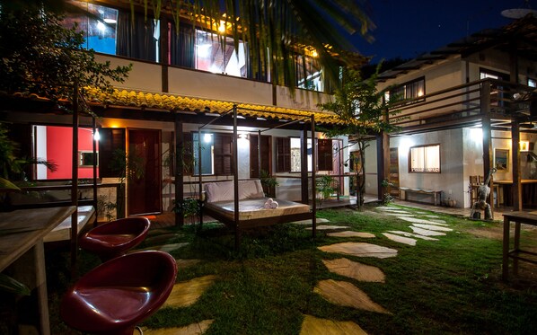 A courtyard with a bed, chairs, and a stone pathway.