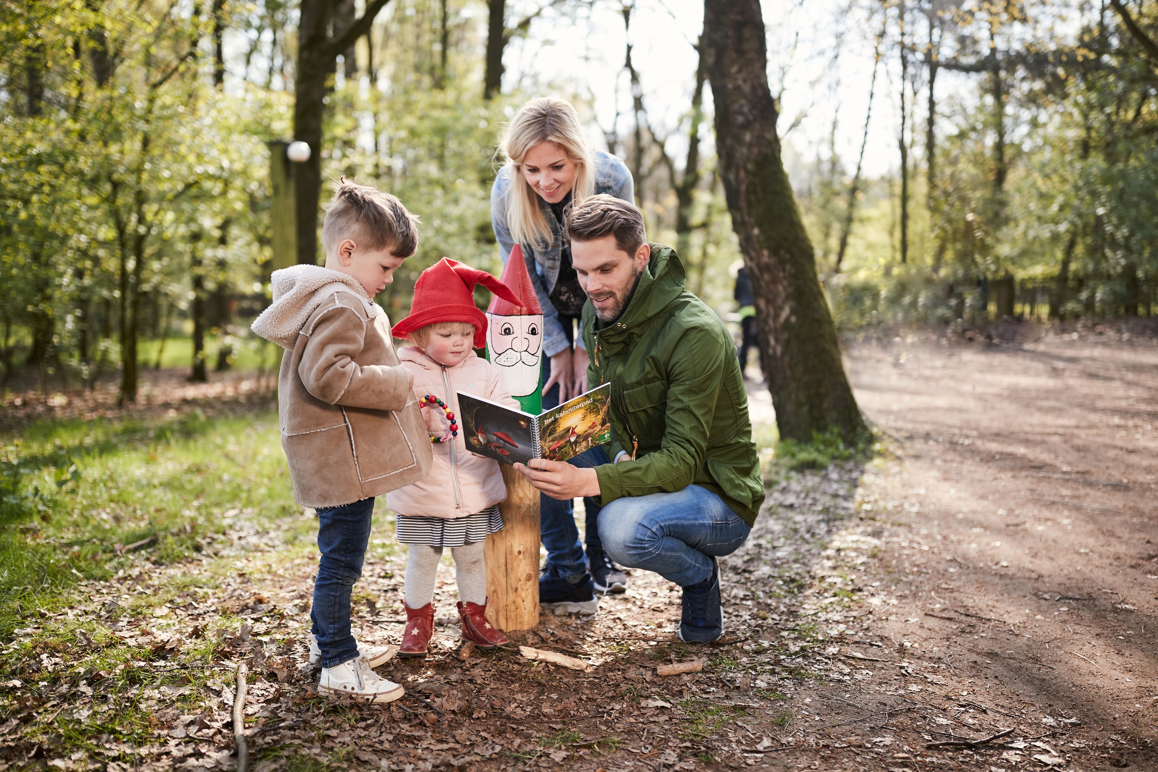 A family in a forested area with a dirt path.
