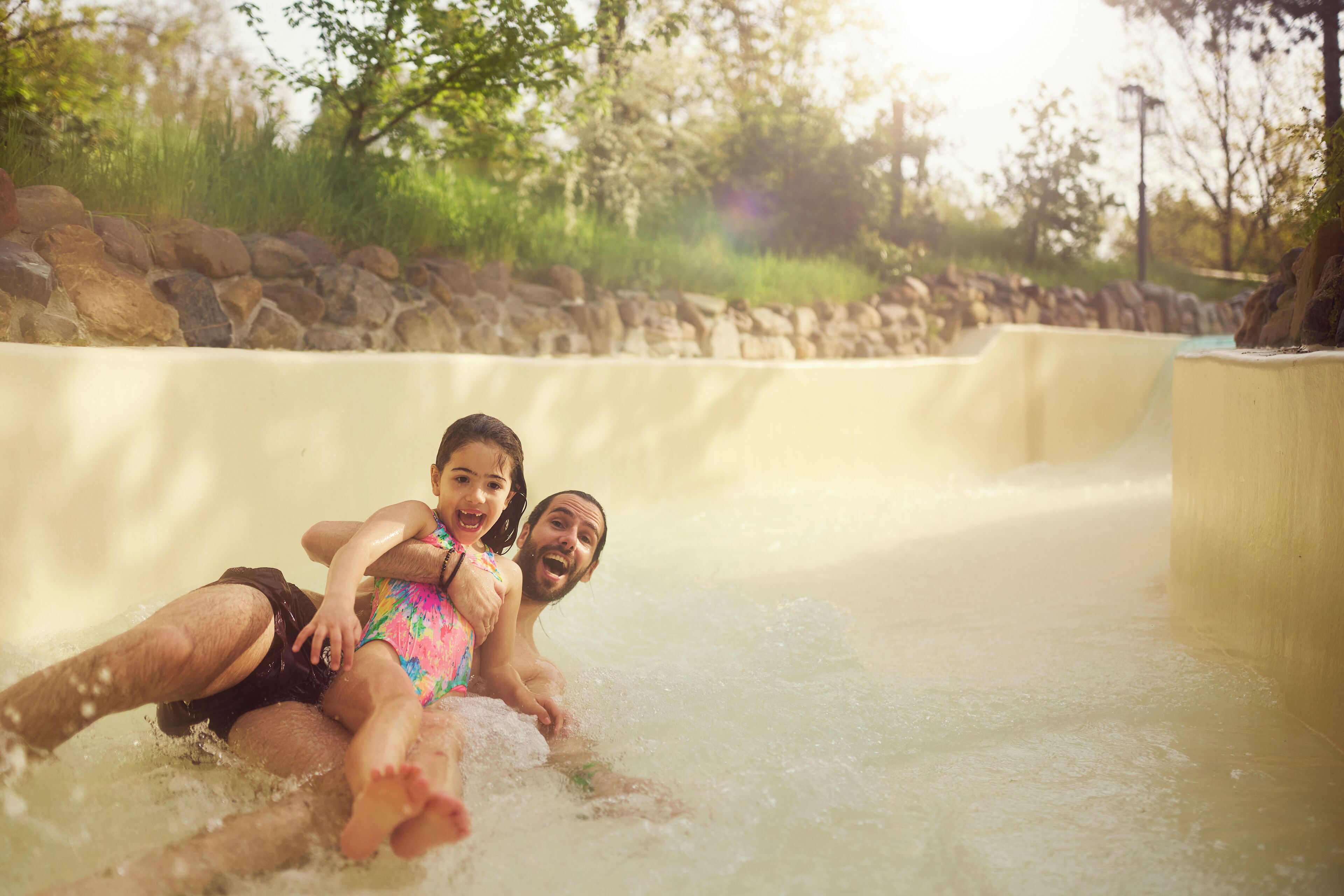 A water slide with a person and a child at the bottom.