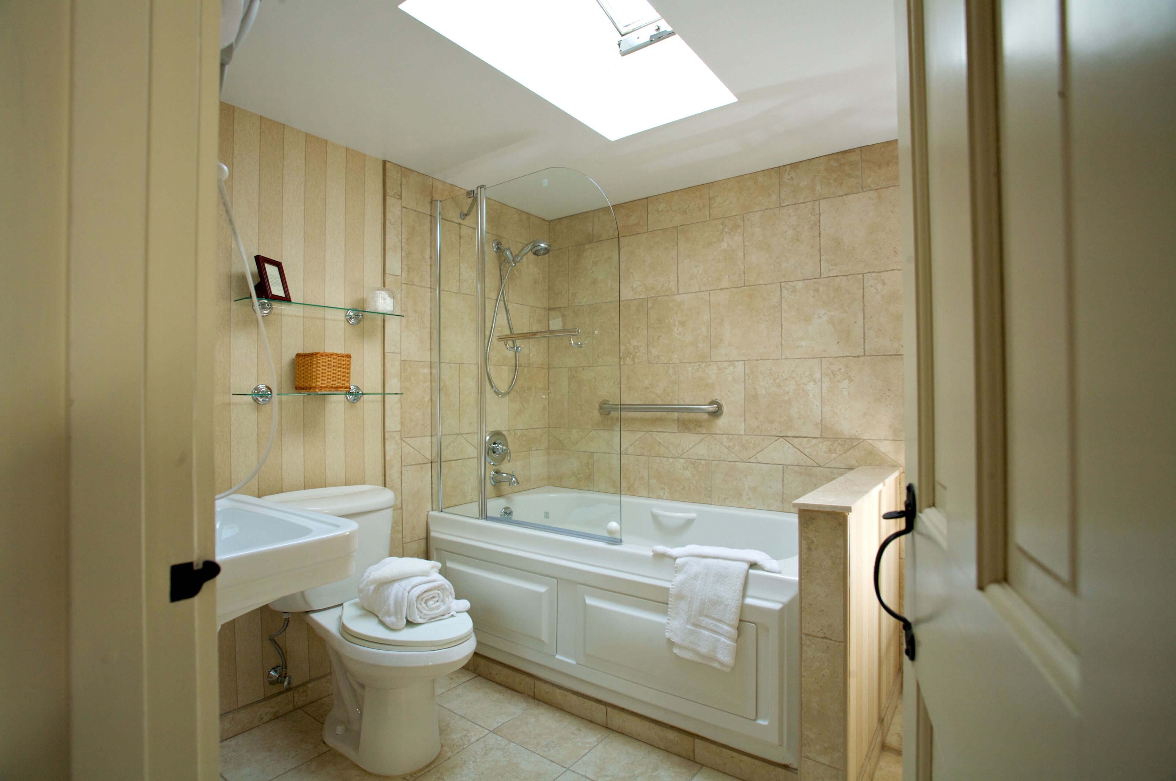 A modern bathroom with a glass-enclosed shower, a freestanding bathtub, and a toilet.