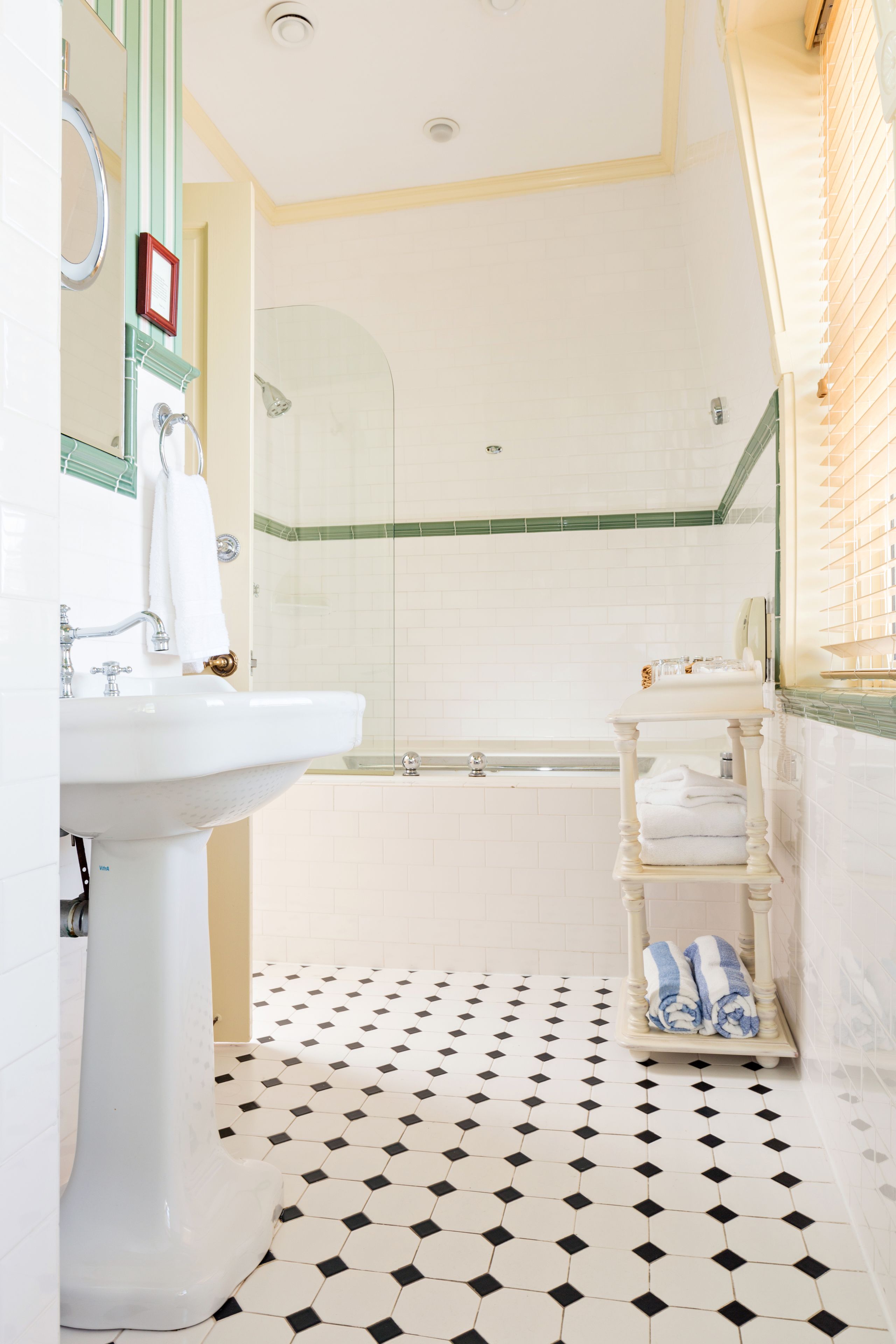 A bathroom with a white sink, a glass-enclosed shower, a bathtub, and a tiled floor.