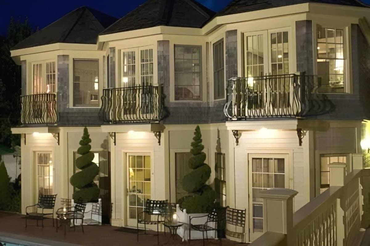 A multi-story residential building with balconies, large windows, and outdoor seating.