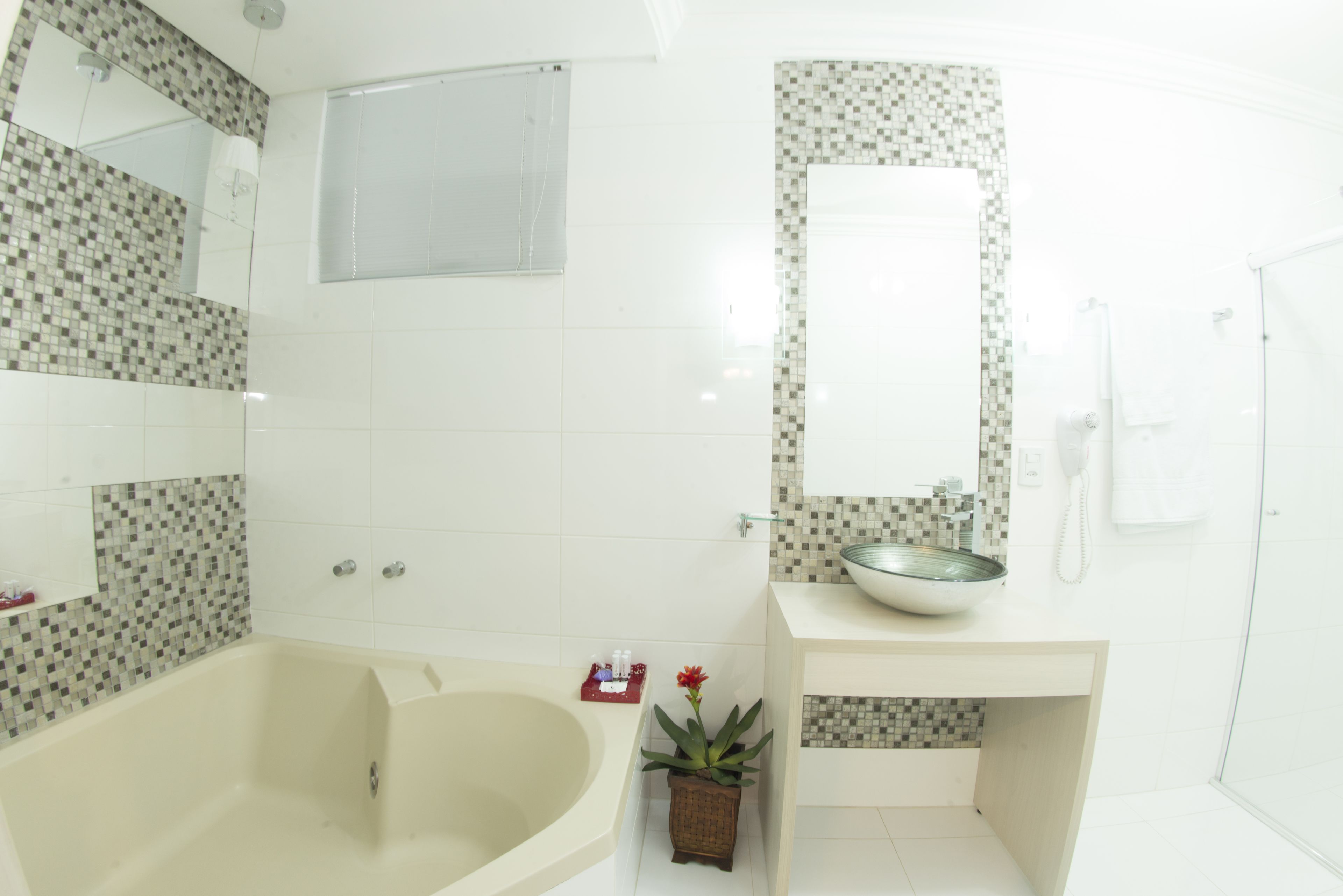 A modern bathroom with a freestanding bathtub, a glass sink, and a shower area.